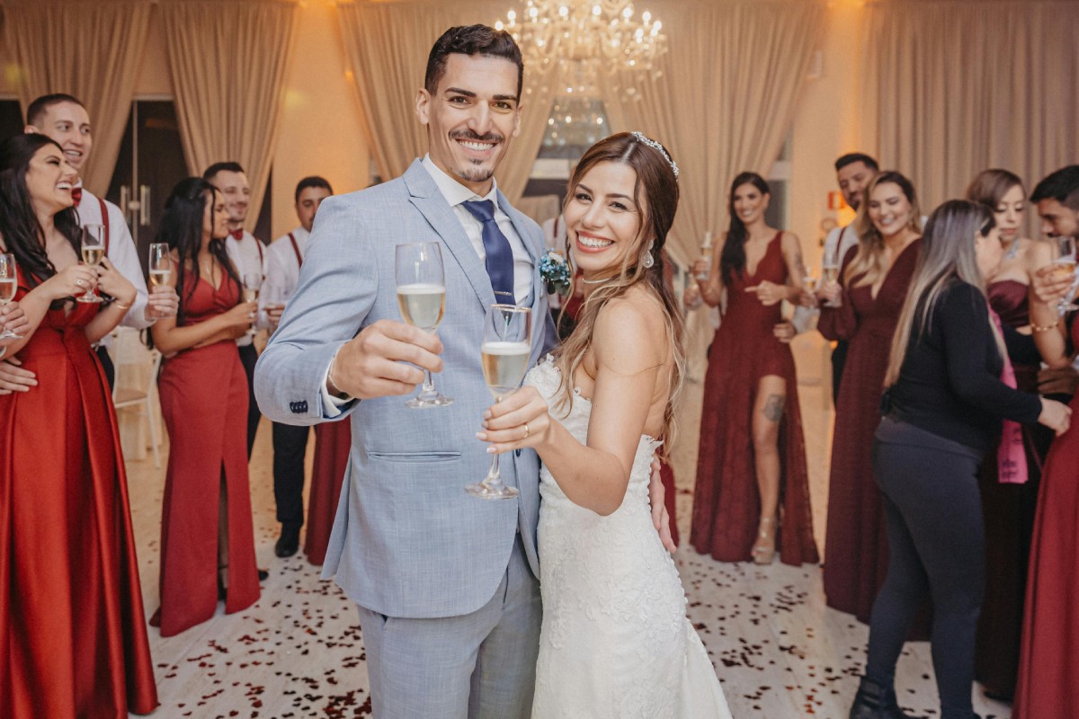 Couple souriant au centre de la réception, entouré d'invités élégamment habillés, illustrant le respect du dress code et des bonnes attitudes à adopter lors d’un mariage.